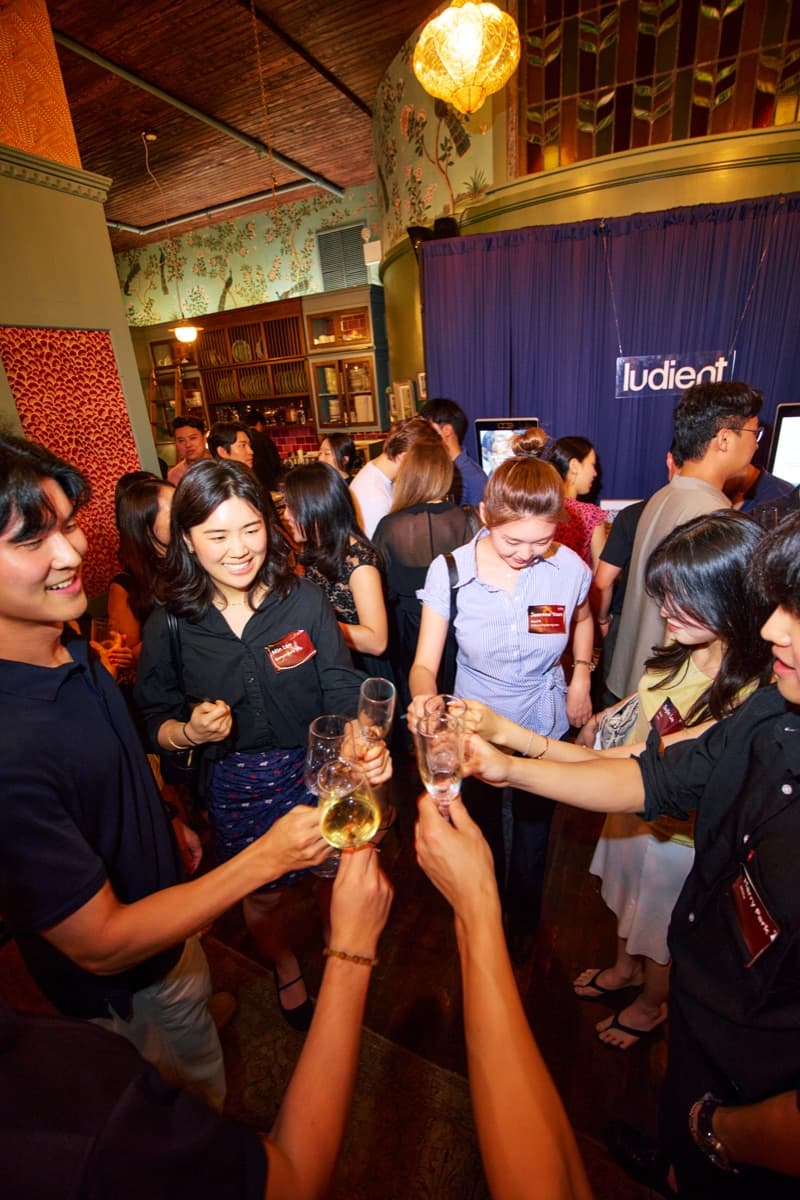 A champagne toast in front of the ludient booth at a Mesh event